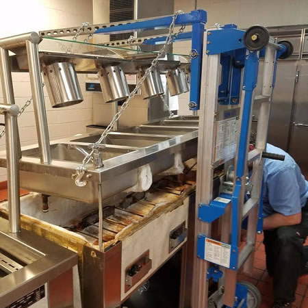 Technician repairing a commercial range in a Hendersonville TN restaurant kitchen